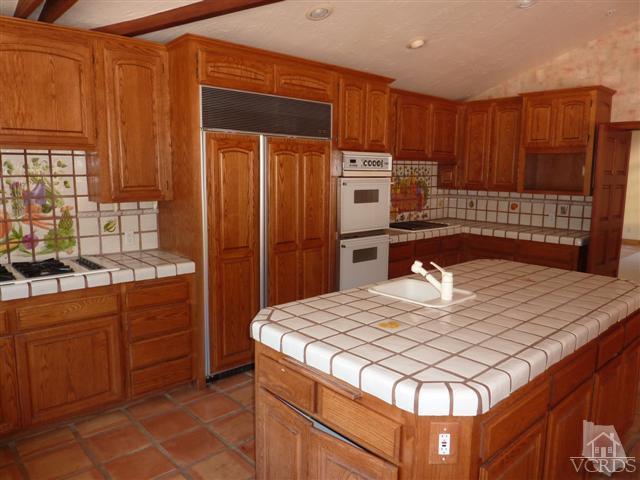 51 Buckskin Road Bell Canyon, CA 91307 - Photo 7 of 24 a kitchen with stainless steel appliances kitchen island granite countertop a table chairs in it and wooden floors