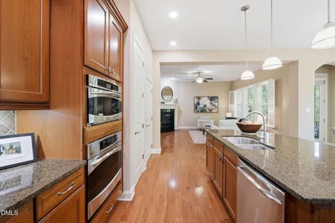 a kitchen with stainless steel appliances granite countertop a stove a sink and a microwave