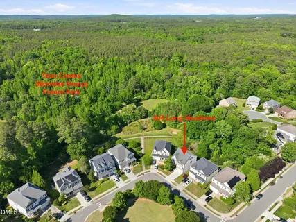 an aerial view of residential house with outdoor space and trees all around