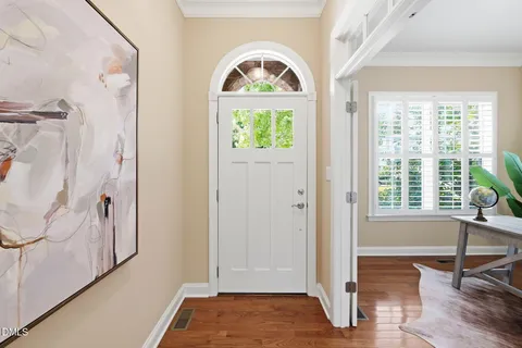 a view of a hallway with wooden floor and staircase