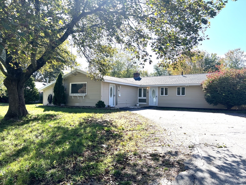 a front view of house with yard and trees around