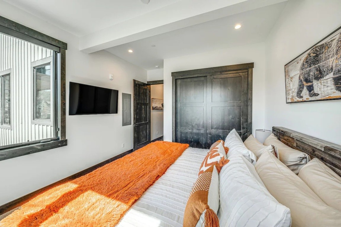 72 Meadow Trail, Unit 104 Fraser, CO 80442 - Photo 11 of 21 a bed sitting in a bedroom and a flat tv screen