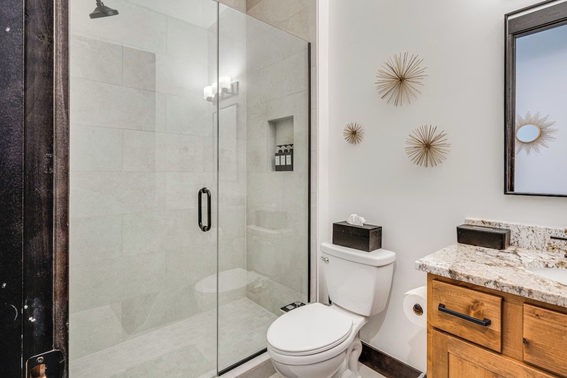 72 Meadow Trail, Unit 104 Fraser, CO 80442 - Photo 14 of 21 a bathroom with a granite countertop toilet a sink and shower