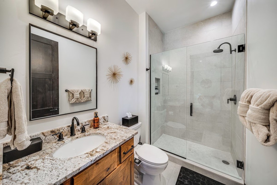 72 Meadow Trail, Unit 104 Fraser, CO 80442 - Photo 10 of 21 a bathroom with a granite countertop sink toilet and shower