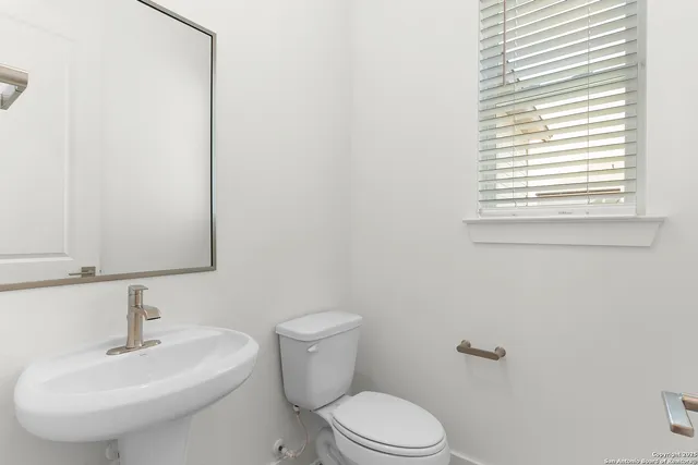 a bathroom with a sink a toilet and a mirror