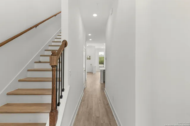 a view of a hallway with wooden floor and staircase