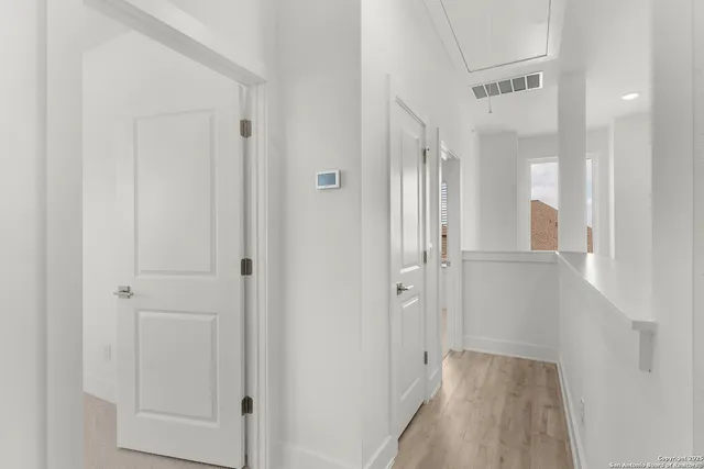 a view of a hallway with wooden floor