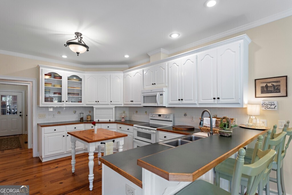 426 Wadley Coleman Lake Road Swainsboro, GA 30401 - Photo 20 of 79 a kitchen with a dining table chairs sink and cabinets