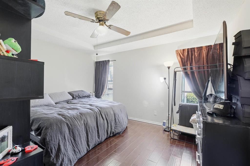 324 Bowie Street Forney, TX 75126 - Photo 11 of 25 a bedroom with a bed and a flat tv screen on the dresser