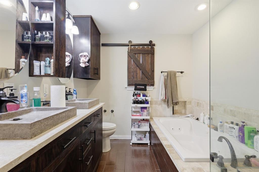 324 Bowie Street Forney, TX 75126 - Photo 14 of 25 a bathroom with a tub sink and mirror