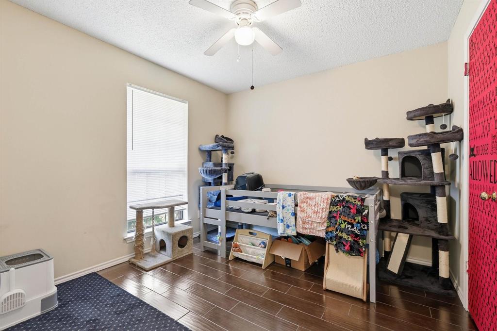 324 Bowie Street Forney, TX 75126 - Photo 16 of 25 a bedroom with furniture and a book shelf