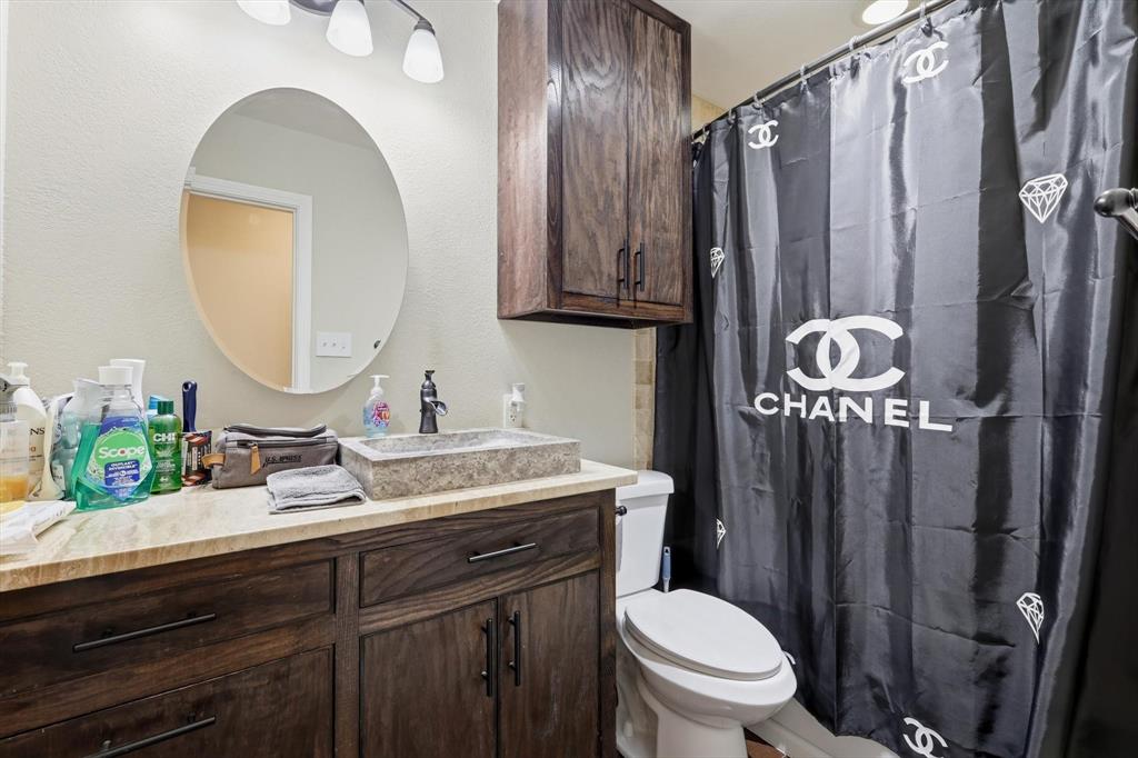 324 Bowie Street Forney, TX 75126 - Photo 17 of 25 a bathroom with a granite countertop sink mirror vanity and toilet