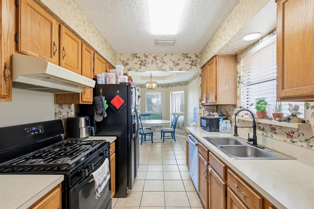 324 Bowie Street Forney, TX 75126 - Photo 8 of 25 a kitchen with stainless steel appliances granite countertop a sink stove and cabinets