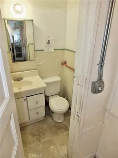 a bathroom with a toilet sink and mirror