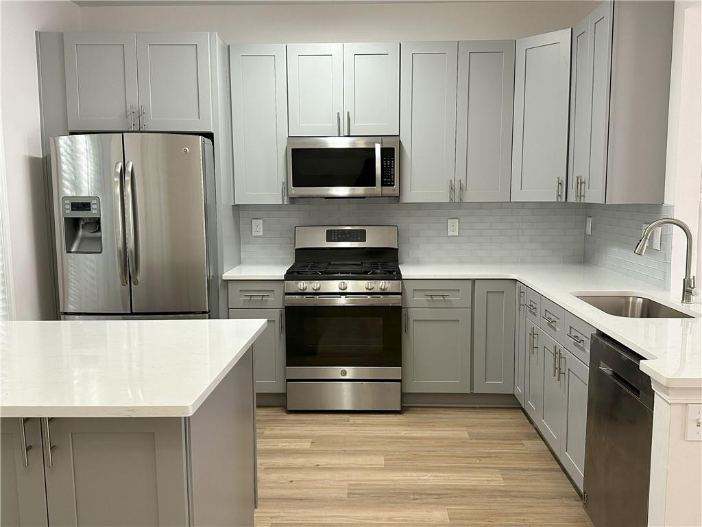 4162 Howell Park Road Duluth, GA 30096 - Photo 1 of 16 a kitchen with granite countertop a refrigerator stove and microwave