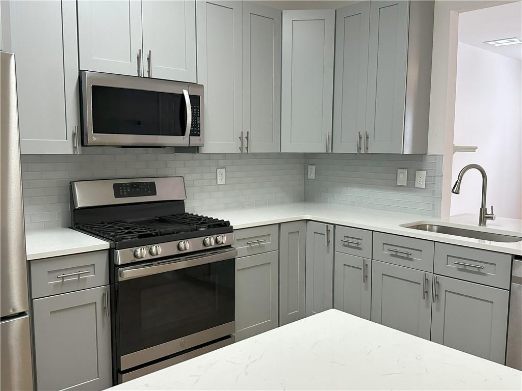 4162 Howell Park Road Duluth, GA 30096 - Photo 3 of 16 a kitchen with a stove and a microwave
