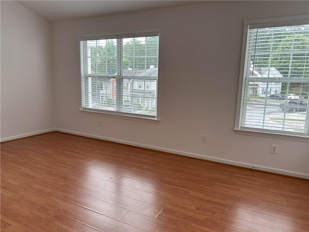 4162 Howell Park Road Duluth, GA 30096 - Photo 8 of 16 a view of an empty room with wooden floor and a window