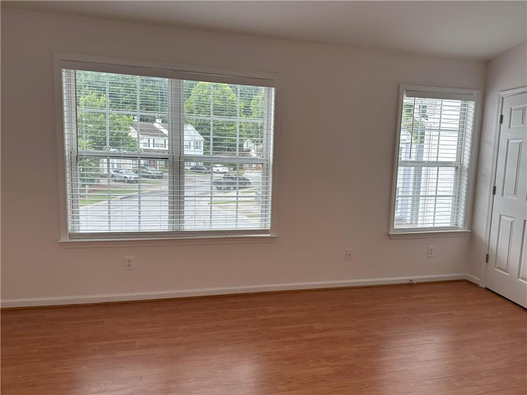 4162 Howell Park Road Duluth, GA 30096 - Photo 9 of 16 a view of an empty room with wooden floor and a window
