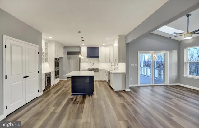 a living room with stainless steel appliances kitchen island granite countertop furniture wooden floor and view living room