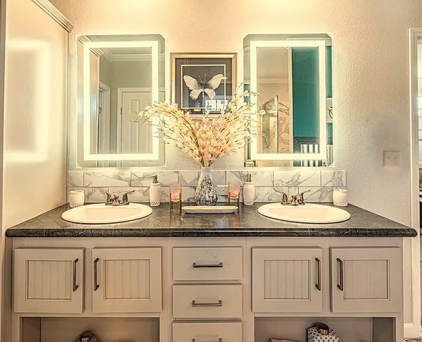 a bathroom with double sink and a mirror