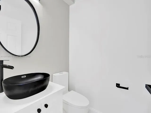 a bathroom with a toilet and a mirror