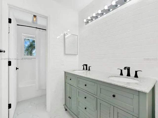 a bathroom with a double vanity sink a mirror and shower