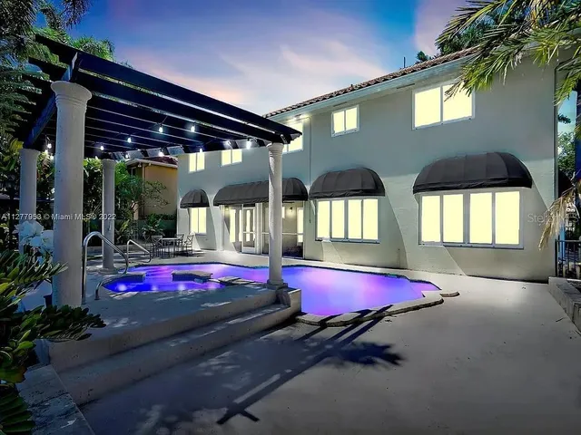 a view of a pool with red chairs