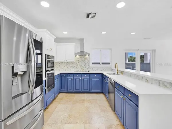 a kitchen with stainless steel appliances granite countertop a sink refrigerator and cabinets
