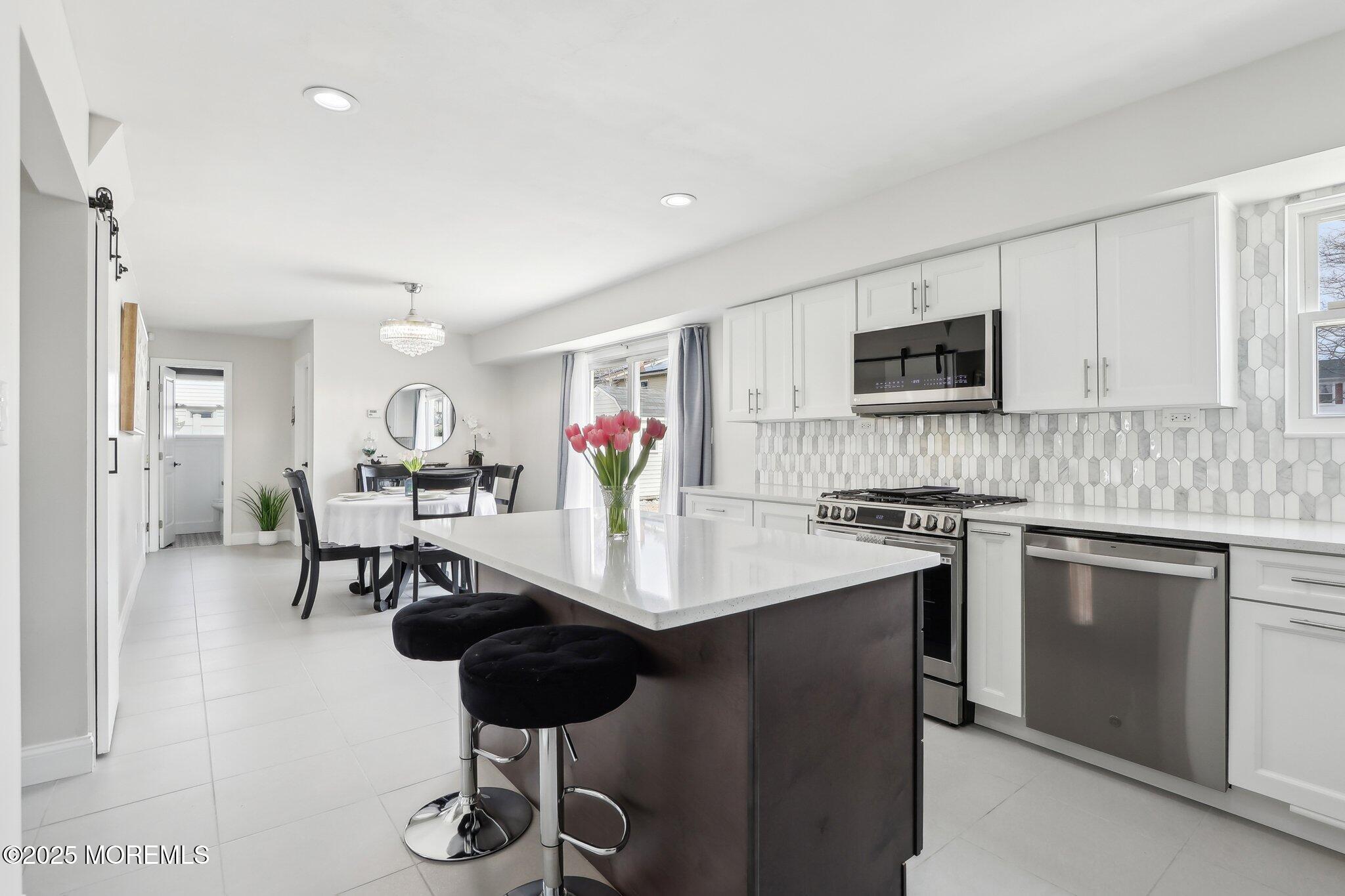 572 Line Road Hazlet, NJ 07730 - Photo 16 of 39 a kitchen with stainless steel appliances kitchen island granite countertop a stove a sink a microwave and a refrigerator