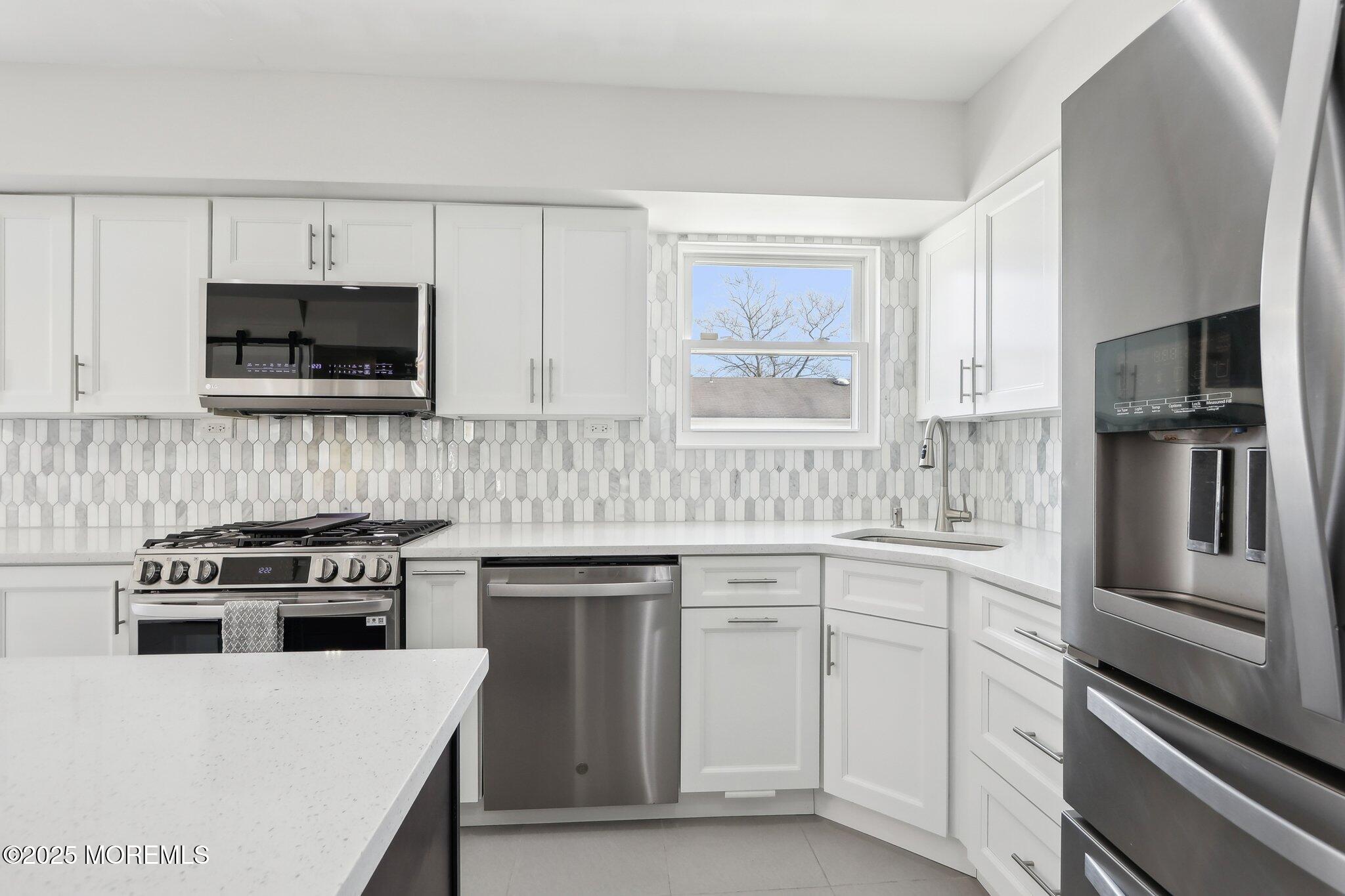 572 Line Road Hazlet, NJ 07730 - Photo 17 of 39 a kitchen with white cabinets and stainless steel appliances