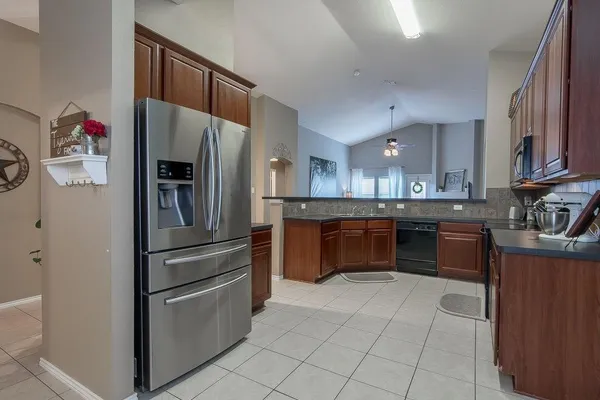 a kitchen with stainless steel appliances and chandelier