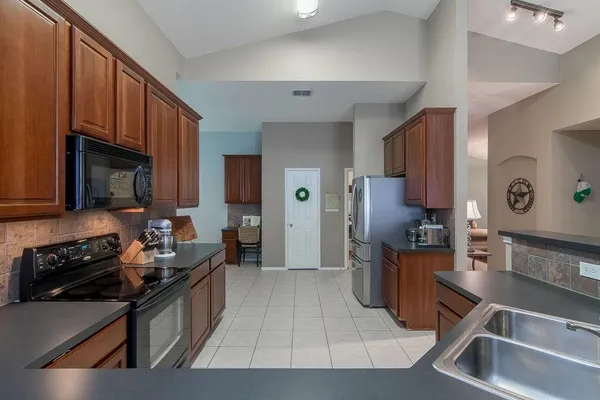 a kitchen with stainless steel appliances a sink stove and refrigerator