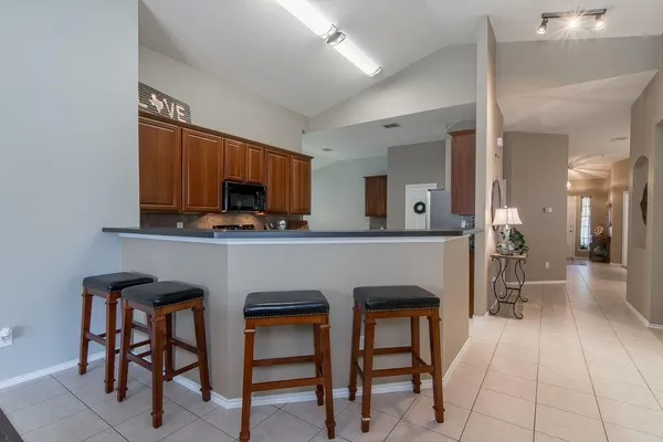 a kitchen with a table chairs refrigerator and microwave