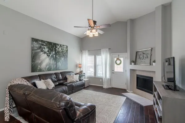a living room with furniture a fireplace and a flat screen tv