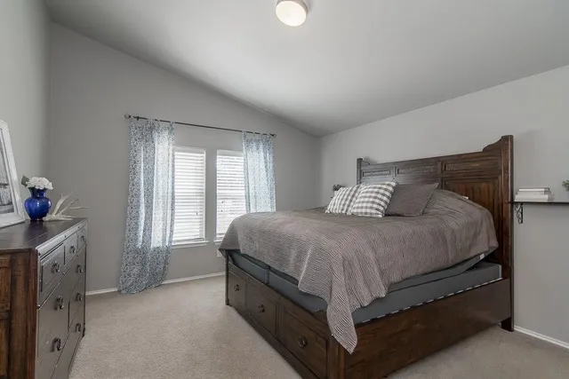 a spacious bedroom with a bed and a window