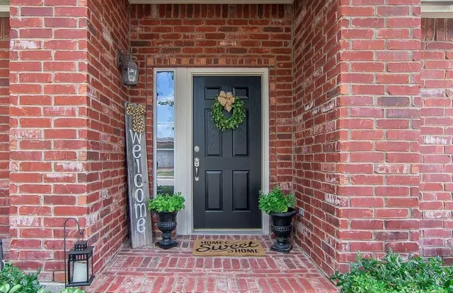 a view of a brick house with potted plants