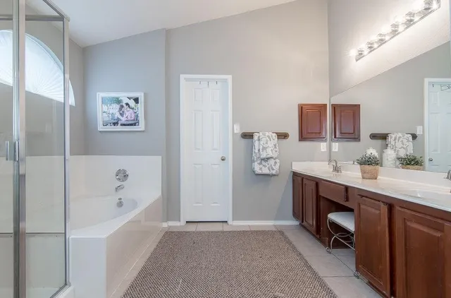 a bathroom with a tub sink and mirror