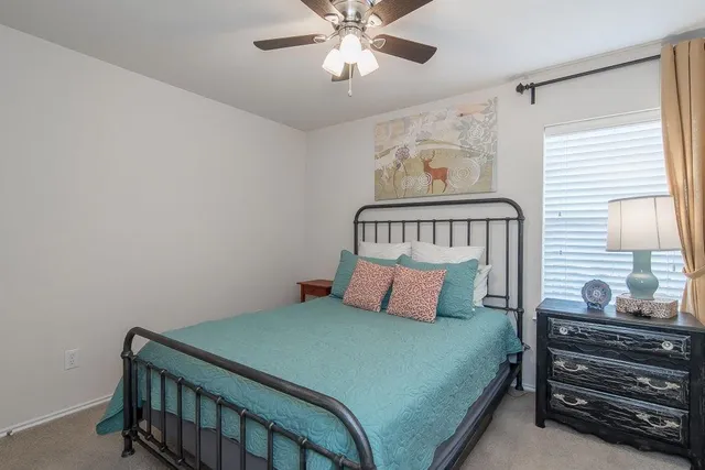 a bedroom with a bed and ceiling fan