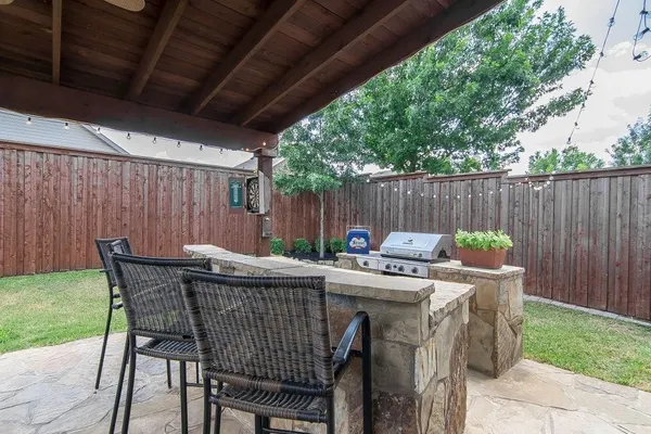 a view of backyard with table and chairs