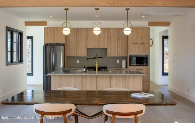 a kitchen with stainless steel appliances granite countertop a sink a stove and a refrigerator