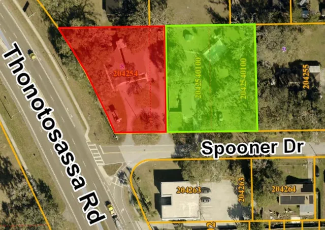 an aerial view of residential houses with outdoor space and trees