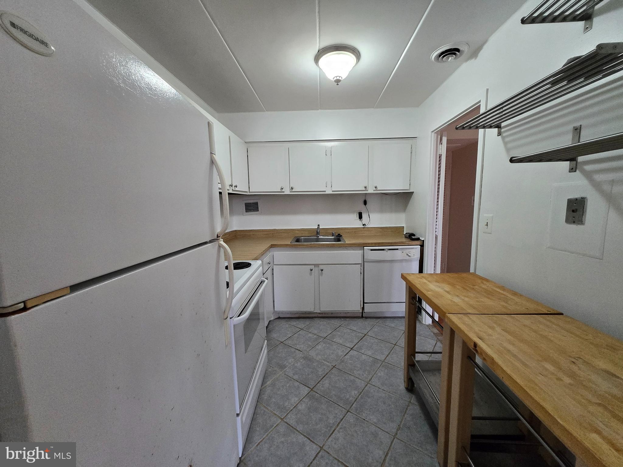 2614 Fort Farnsworth Road, Unit 254 Alexandria, VA 22303 - Photo 3 of 11 a kitchen with a sink a stove a refrigerator and white cabinets