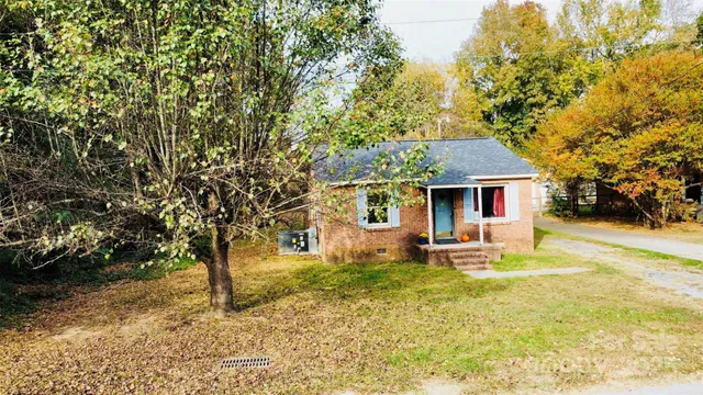 a front view of a house with a yard and trees