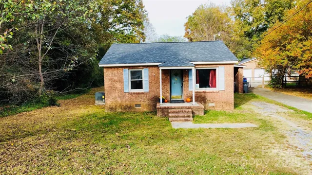 a front view of house with yard and trees around