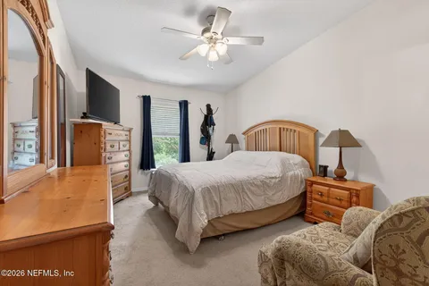 a bedroom with a bed a couch and a chandelier