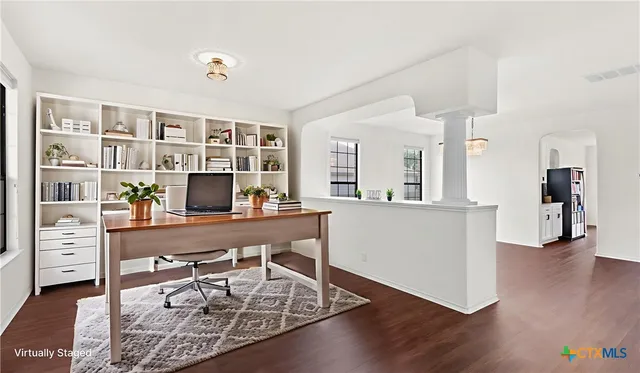 a view of a workspace with furniture and wooden floor