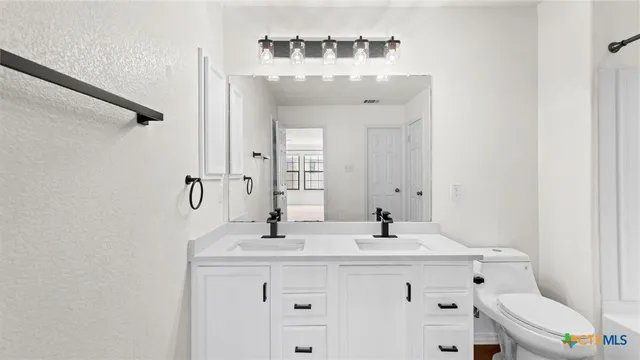 a bathroom with a sink mirror and toilet