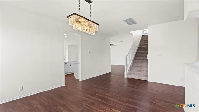 an empty room with wooden floor and hallway