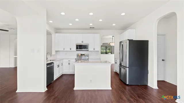 a kitchen with stainless steel appliances a refrigerator and a stove top oven
