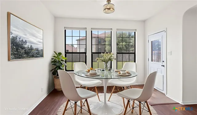 a dining room with furniture wooden floor and a potted plant
